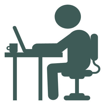 Ikon af medarbejder der sidder om arbejder ved et skrivebord med en computer.